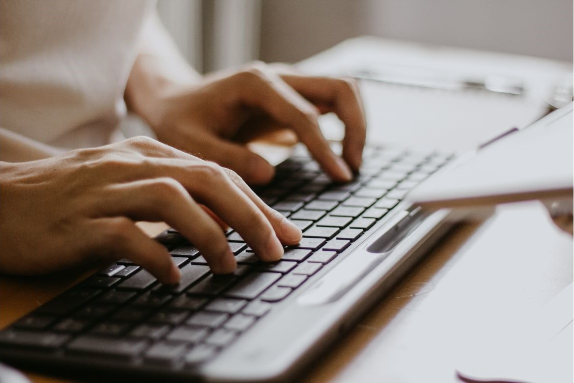Hands typing on a keyboard.
